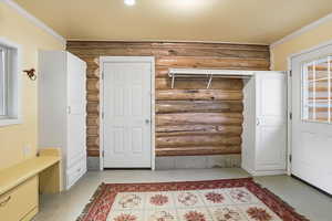 Mudroom with ornamental molding and finished concrete flooring