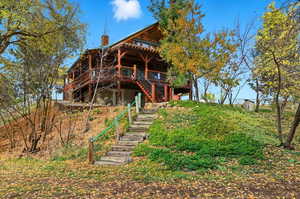 Rear view of property with a wooden deck, stairs, and a chimney