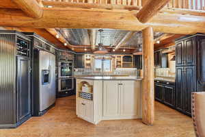 Kitchen with open shelves, beam ceiling, light wood finished floors, stainless steel appliances, and tasteful backsplash
