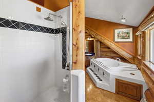 Bathroom featuring a stall shower, vaulted ceiling, and recessed lighting