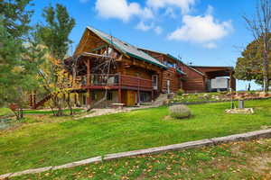 Rear view of property with a deck, stairway, log exterior, and a yard