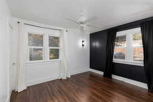 Spare room featuring dark wood finished floors and ceiling fan