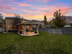 Rear view of house featuring a fenced backyard and a patio