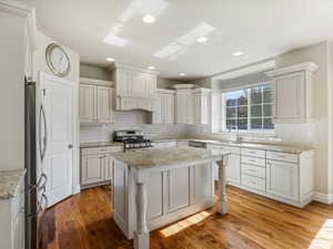 Kitchen featuring stainless steel appliances, tasteful backsplash, light wood-style floors, and recessed lighting