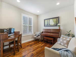 Office space with dark wood-type flooring and recessed lighting