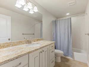 Bathroom with vanity, light tile patterned floors, shower / tub combo with curtain, and recessed lighting