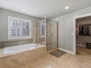 Full bath with a spacious closet, a stall shower, a garden tub, recessed lighting, and tile patterned flooring