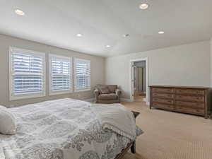 Bedroom with carpet, vaulted ceiling, recessed lighting, and ensuite bath