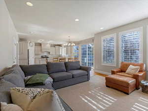 Living room with recessed lighting, a chandelier, and wood finished floors