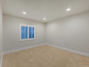 Empty room with recessed lighting and light carpet