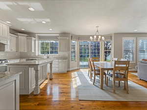 Dining space featuring recessed lighting, light wood-type flooring, a chandelier, and a textured ceiling