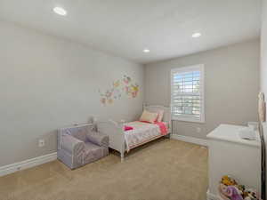 Bedroom with light colored carpet and recessed lighting