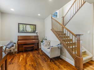 Staircase featuring wood finished floors and recessed lighting
