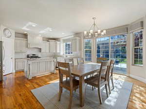 Dining room with light wood-type flooring, a chandelier, and recessed lighting