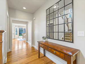 Corridor featuring light wood-style floors, a chandelier, and recessed lighting