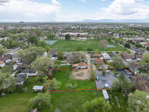 Aerial view of residential area featuring property boundaries highlighted and a mountain backdrop