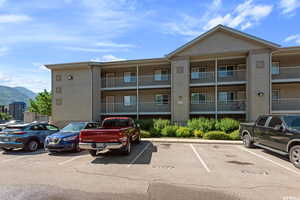 View of building exterior featuring uncovered parking and a mountain view