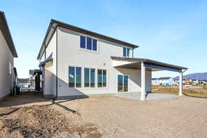 Rear view of property with a patio, stucco siding, and a residential view