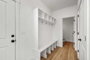 Mudroom featuring light wood-style floors and baseboards
