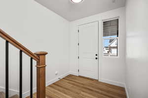 Entrance foyer with stairs and light wood-style floors