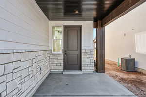 Doorway to property featuring stone siding