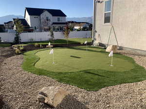 Surrounding community with a mountain view and an area to practice putting