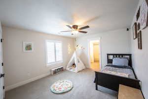 Carpeted bedroom featuring a textured ceiling, a ceiling fan, and ensuite bathroom