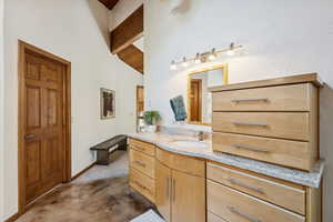 Bathroom featuring vanity and dark carpet