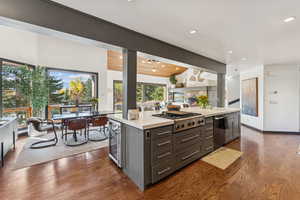 Kitchen with a center island, open floor plan, dark wood finished floors, light stone counters, and beverage cooler