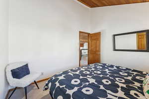 Bedroom featuring carpet flooring, wooden ceiling, and a towering ceiling
