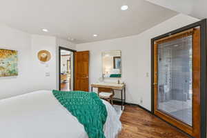 Bedroom with dark wood-style flooring, recessed lighting, and access to outside