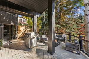 Deck with area for grilling and an outdoor living space with a fire pit