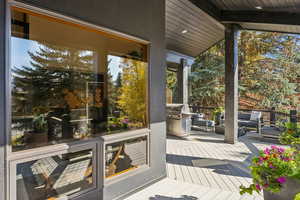 Doorway with wooden ceiling, expansive windows, and a sunroom