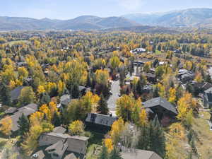Aerial view of property and surrounding area featuring a mountainous background