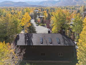 View of subject property featuring a mountainous background and a heavily wooded area