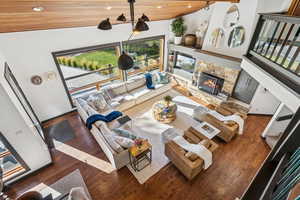 Living area featuring wood finished floors, a fireplace, wooden ceiling, recessed lighting, and a high ceiling