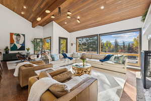 Living room featuring wood finished floors, high vaulted ceiling, a glass covered fireplace, wooden ceiling, and recessed lighting