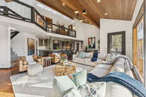 Living area with recessed lighting, wood finished floors, high vaulted ceiling, stairway, and wooden ceiling