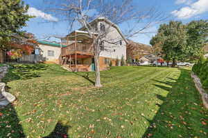 Back of property with stairs, a patio, a deck, and a yard