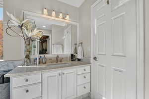 Bathroom with vanity and a walk in closet