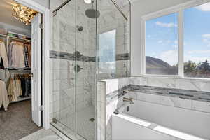 Full bath featuring a garden tub, a walk in closet, and a shower stall