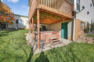Back of property with stairs, a patio area, a hot tub, and stucco siding