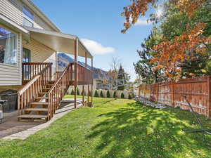 Fenced backyard featuring stairway, a wooden deck, and a patio area