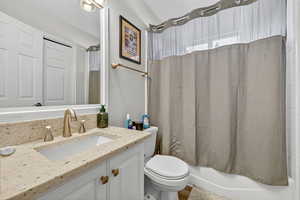 Bathroom featuring shower / bathtub combination with curtain and vanity