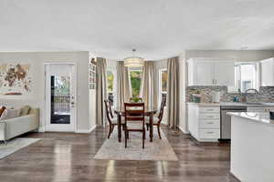 Dining space with a textured ceiling and dark wood-type flooring