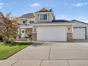 View of front of property with roof with shingles, a front yard, and driveway