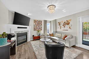 Living area featuring a fireplace, wood finished floors, a chandelier, and a textured ceiling