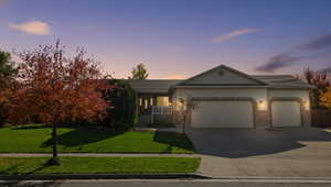 Single story home with a porch, a garage, a yard, and driveway