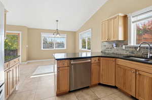 Kitchen with lofted ceiling, dishwasher, light tile patterned flooring, tasteful backsplash, and decorative light fixtures