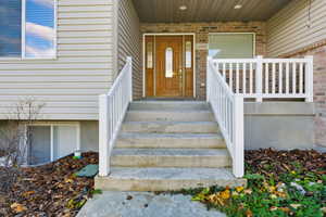 Property entrance featuring brick siding and covered porch